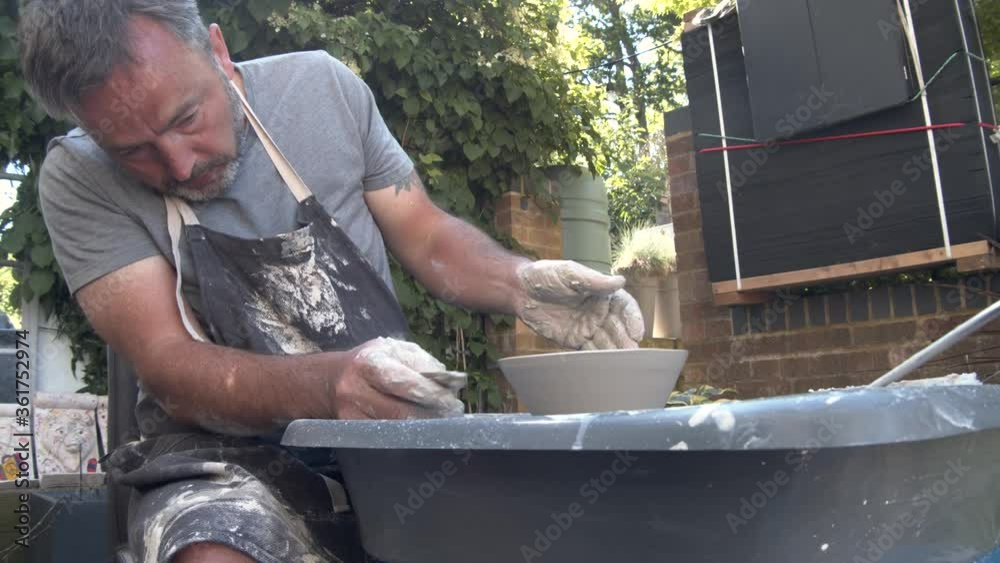 Potter toiling away at his garden wheel in the summer sun Potter toiling away at his garden wheel in the summer sun