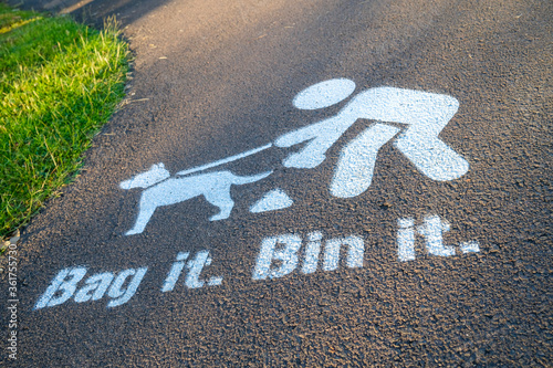 Photography Bag it Bin it painted sign on footpath, encouraging dogs owners to clear up afte