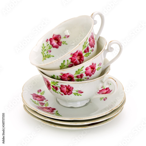 Stack of teacups with floral decoration on a completely white background. Contains clipping path.