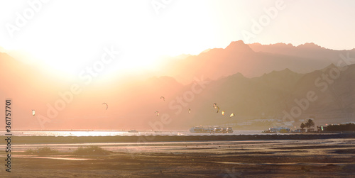Lake of Dahab's desert at sunset with surfers 