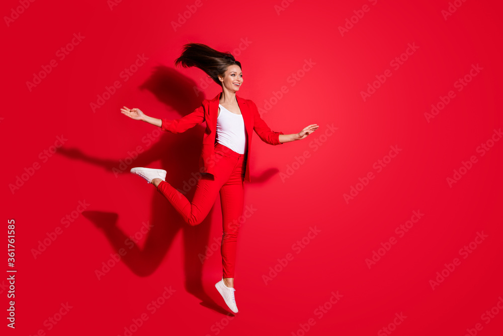 Full length profile photo of attractive worker lady having fun jumping high up good mood vacation having fun wear blazer suit pants footwear isolated bright vivid red color background Full length profile photo of attractive worker lady having fun jumping high up good mood vacation having fun wear blazer suit pants footwear isolated bright vivid red color background