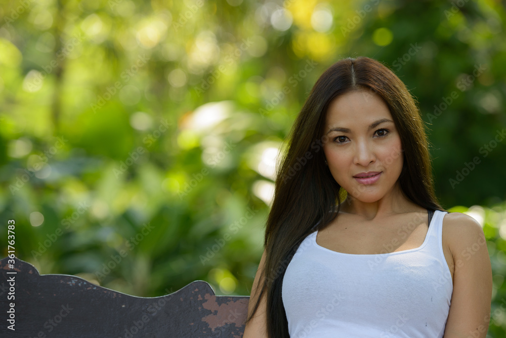 Face of beautiful Asian woman sitting at the park outdoors Face of beautiful Asian woman sitting at the park outdoors