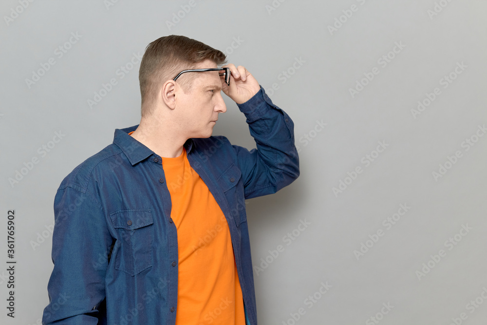 Man is raising glasses on forehead and looking into the distance Man is raising glasses on forehead and looking into the distance