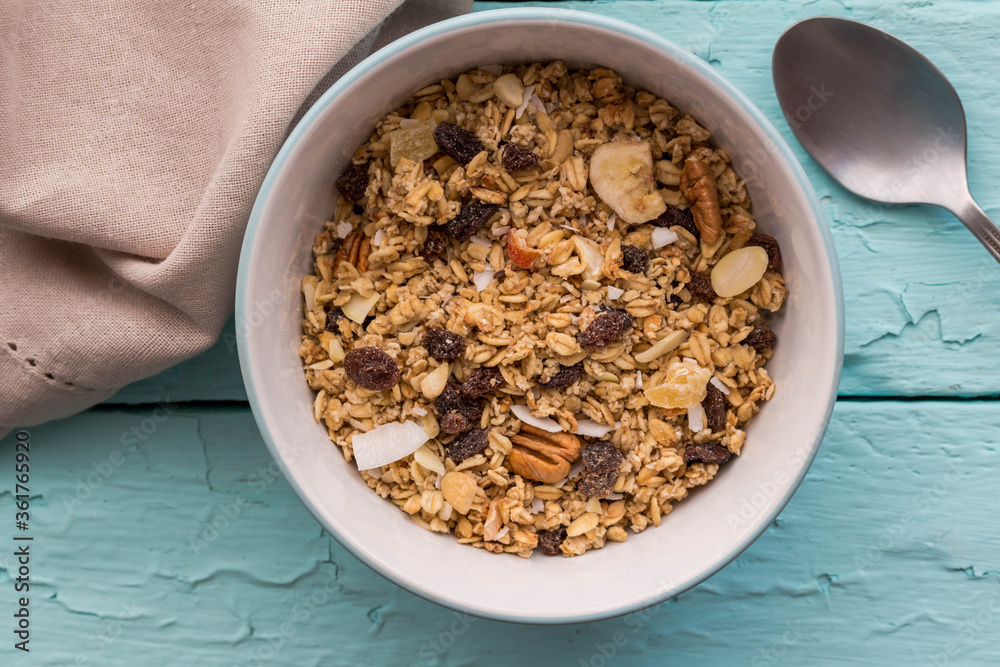 Granola in bowl with raisins,dried banana, nuts - top view breakfast muesli background Granola in bowl with raisins,dried banana, nuts - top view breakfast muesli background