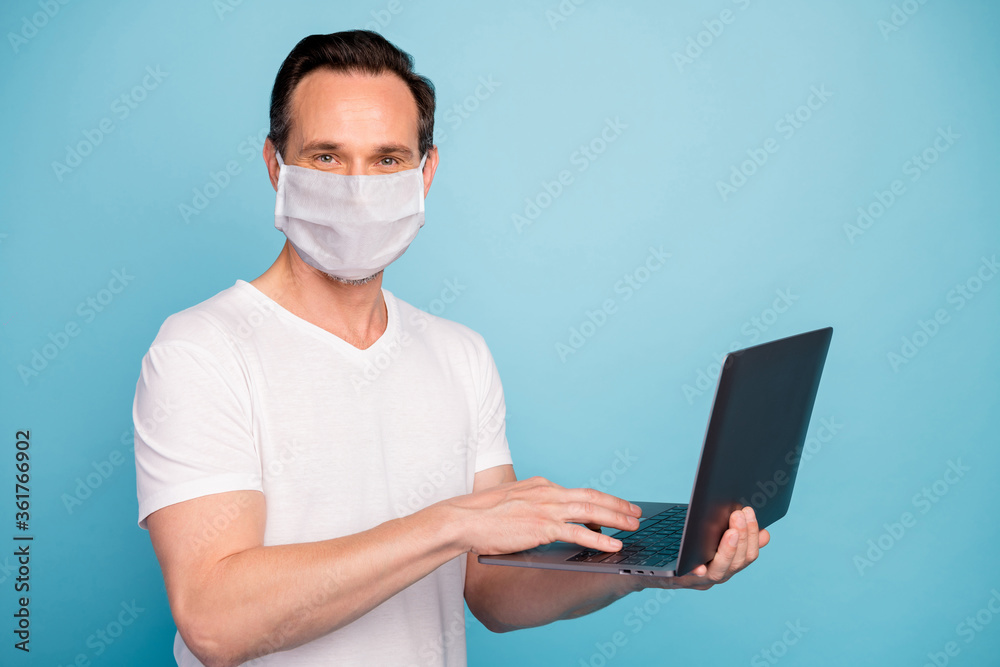 Portrait of his he nice skilled guy wearing safety mask working remotely on laptop watch video lesson stop flu grippe disease case healthcare isolated bright vivid shine vibrant blue color background Portrait of his he nice skilled guy wearing safety mask working remotely on laptop watch video lesson stop flu grippe disease case healthcare isolated bright vivid shine vibrant blue color background