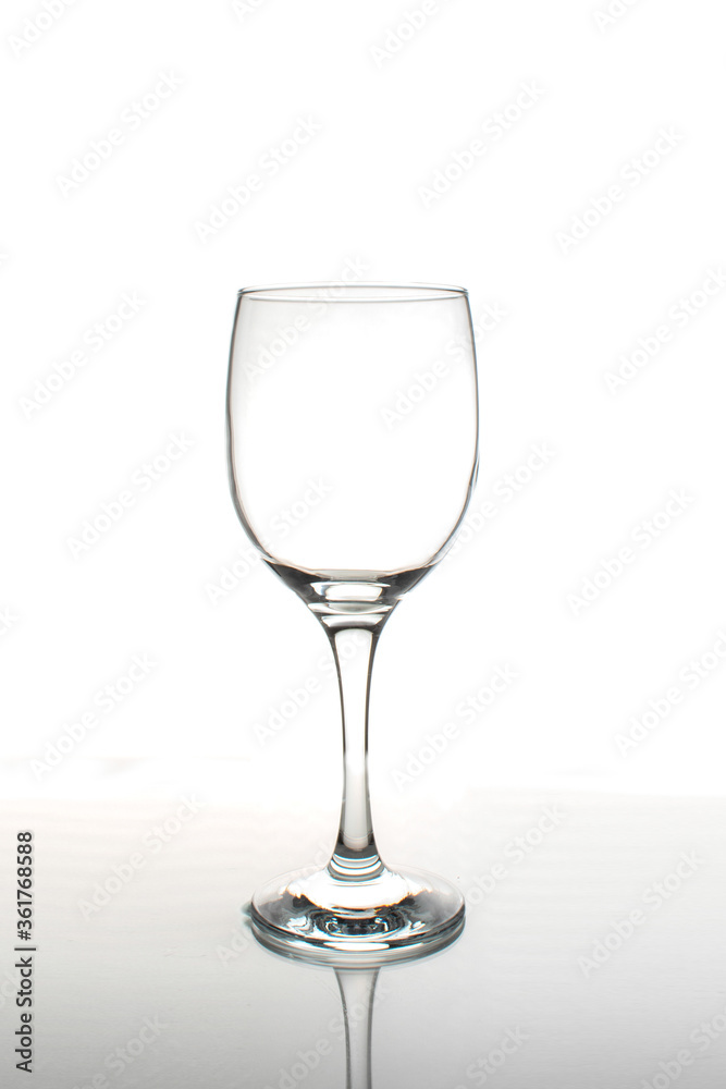 Empty wine glass with reflection on a white background