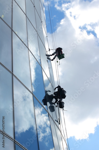 Working-climbers washing the windows on high-rise building.