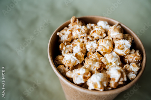 a full box of popcorn top view, a glass of popcorn close-up on a colored background, fast food