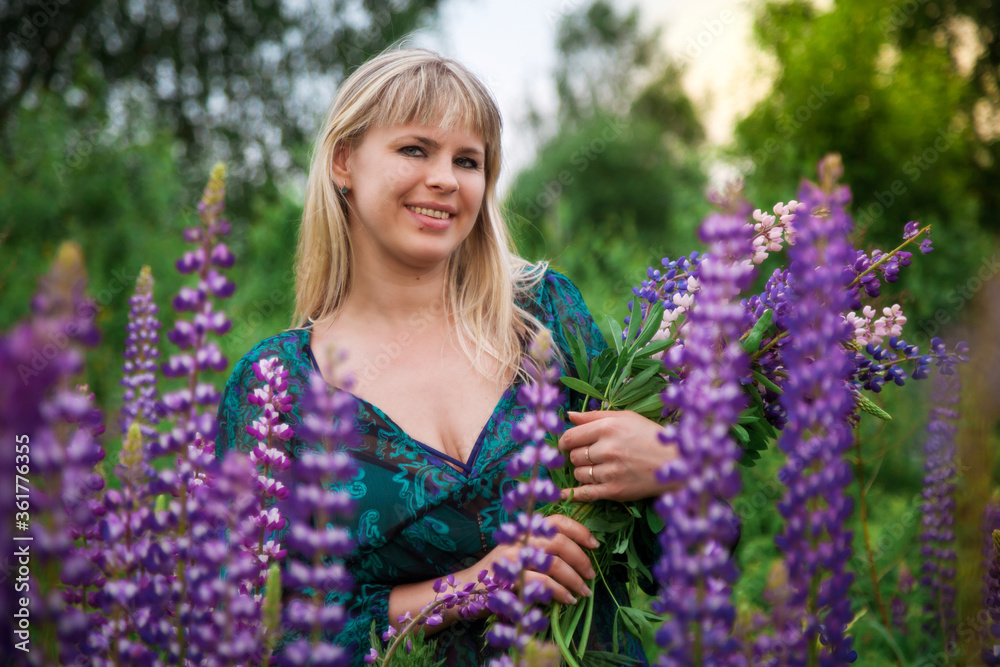 A girl in a Lupin field at sunset. Girl with a bouquet. A girl in a Lupin field at sunset. Girl with a bouquet.