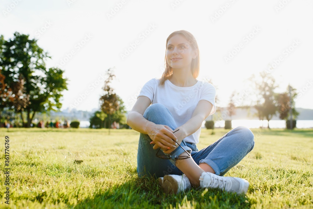 beautiful woman resting in the park on the grass in summer