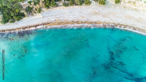 Aerial bird's eye view of Pissouri bay, a village settlement between Limassol and Paphos in Cyprus. The shore, beach with white sand pebbles and crystal clear clean blue water on the shore from above. © f8grapher