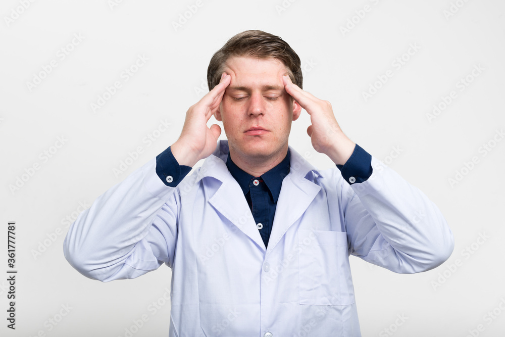 Portrait of stressed young man doctor having headache Portrait of stressed young man doctor having headache