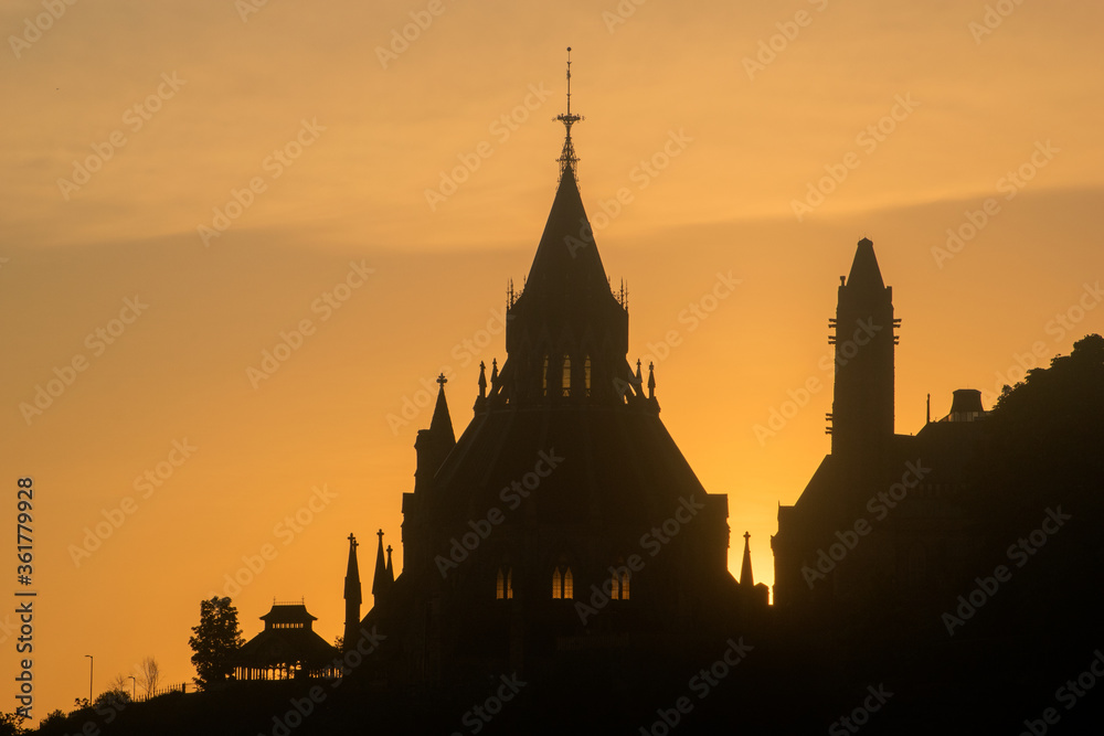 silhouette of parliament buildings in ottawa, canada at dusk against fiery orange sky