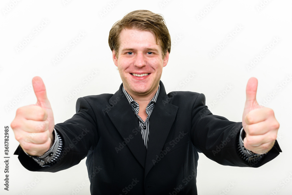 Portrait of happy young handsome businessman giving thumbs up