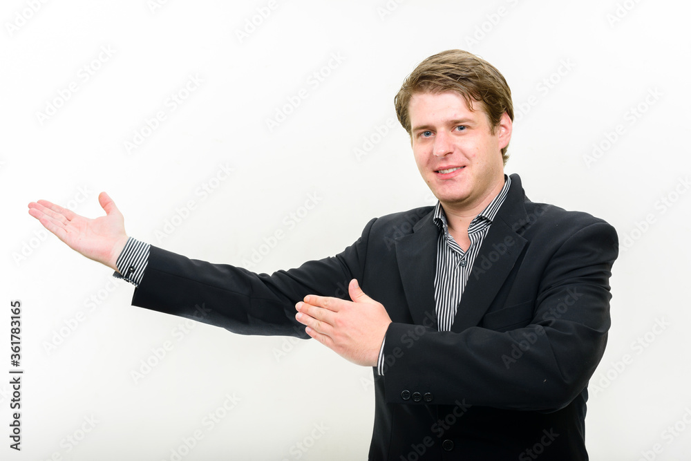 Portrait of happy young handsome businessman showing something Portrait of happy young handsome businessman showing something