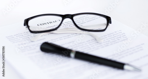 glasses and pen on a sheet of paper close-up. Contacts, business