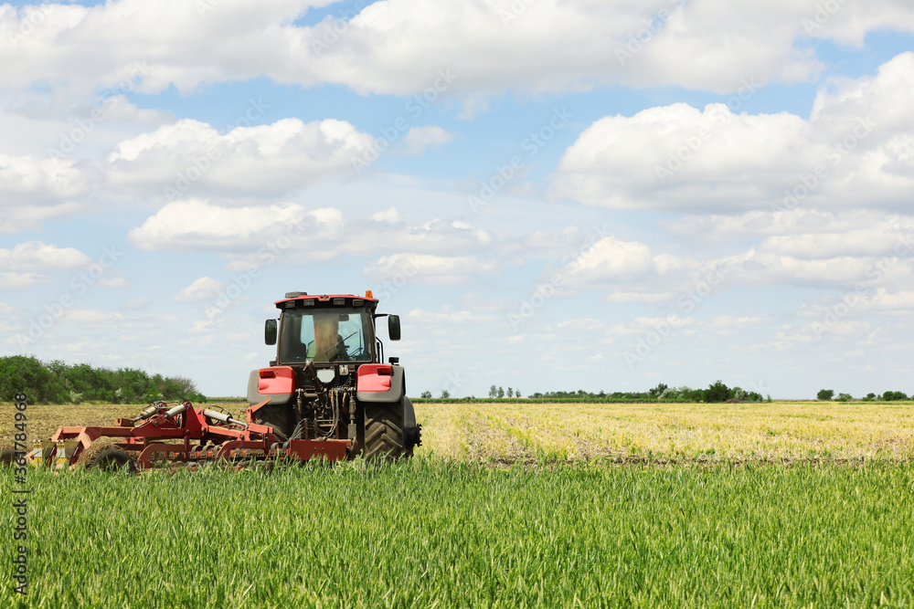 Modern agricultural machinery in field on sunny day Modern agricultural machinery in field on sunny day