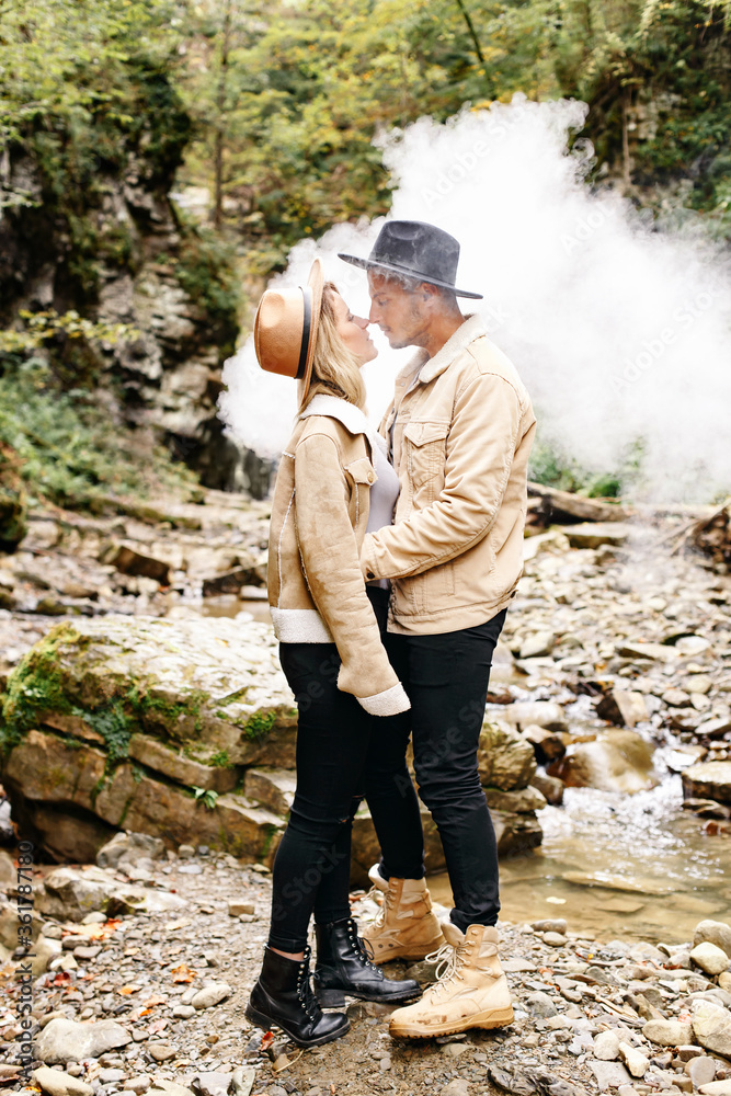 Couple in vape cloud. Two in smoke. Tourists in cold autumn forest with vape. Man and women in smoke. Two smokers. Beautiful couple in fog. E-cigarettes and people.