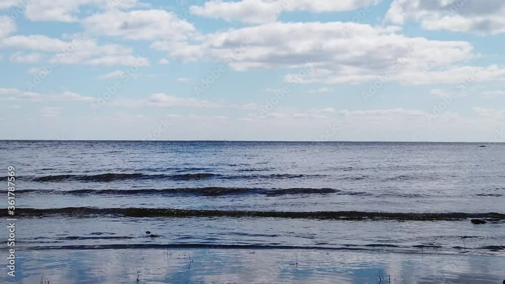 Sea waves are coming to the shore slow motion. water surface with ripples. evening seascape with horizon line. stone thrown into the water