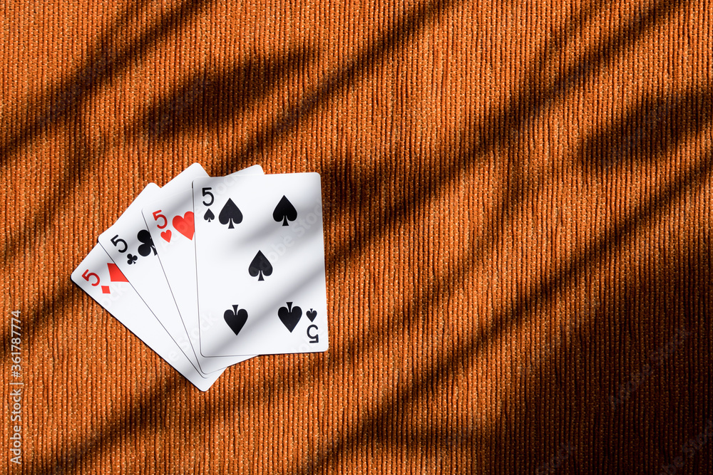 Four of a kind playing cards five, poker card in orange background