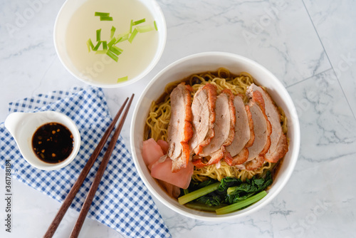 Chinese roasted duck with noodle in bowl on white background as traditional street food