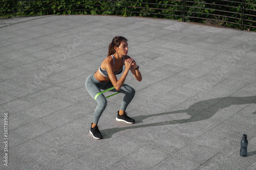 Young woman working out with an exercize band outside