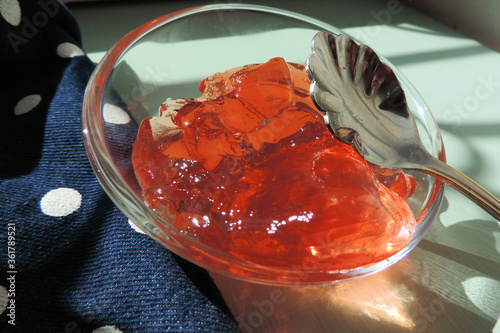   apricot jelly in a dessert bowl with a carved spoon in the shape of a flower       photo