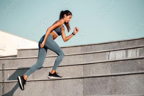 Young woman running at staircase 