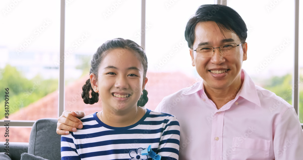Portrait of Happy family with father and daughter smiling and looking at camera.