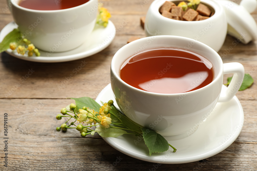 Cup of tea and linden blossom on wooden table Cup of tea and linden blossom on wooden table