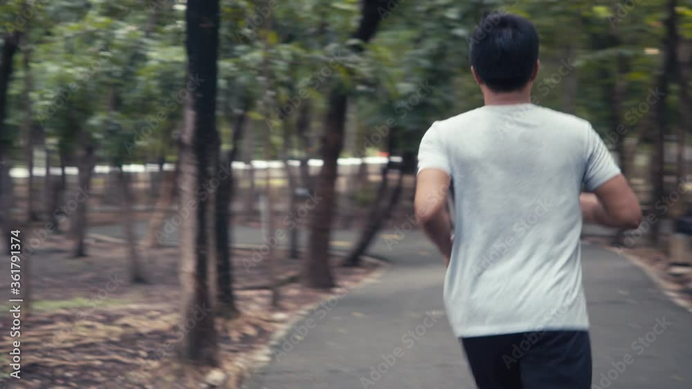 Handsome young asian man jogging running in the public park. athlete exercise training workout healthy outdoors in the forest concept. Handsome young asian man jogging running in the public park. athlete exercise training workout healthy outdoors in the forest concept.