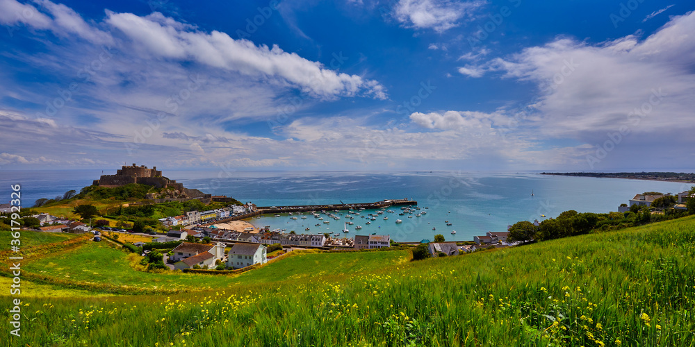 Image of Gorey Castle with Harbour, Grouville Bay calm sea and blue sky and  clouds. Jersey, Channel Islands. Stock Photo | Adobe Stock