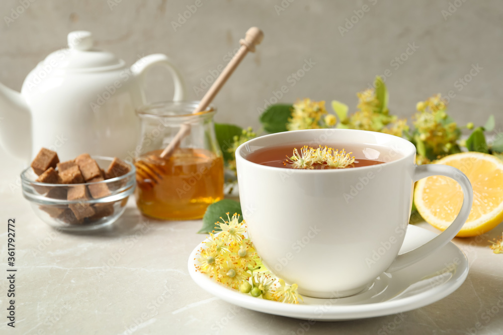 Cup of tea with linden blossom on light grey marble table Cup of tea with linden blossom on light grey marble table