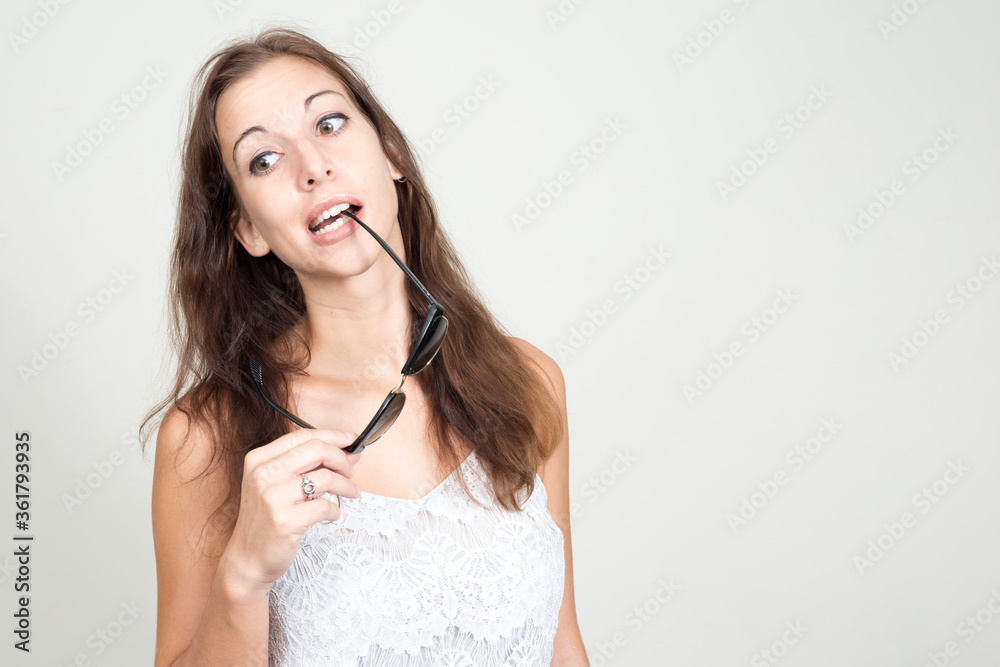 Portrait of young beautiful woman biting sunglasses Portrait of young beautiful woman biting sunglasses