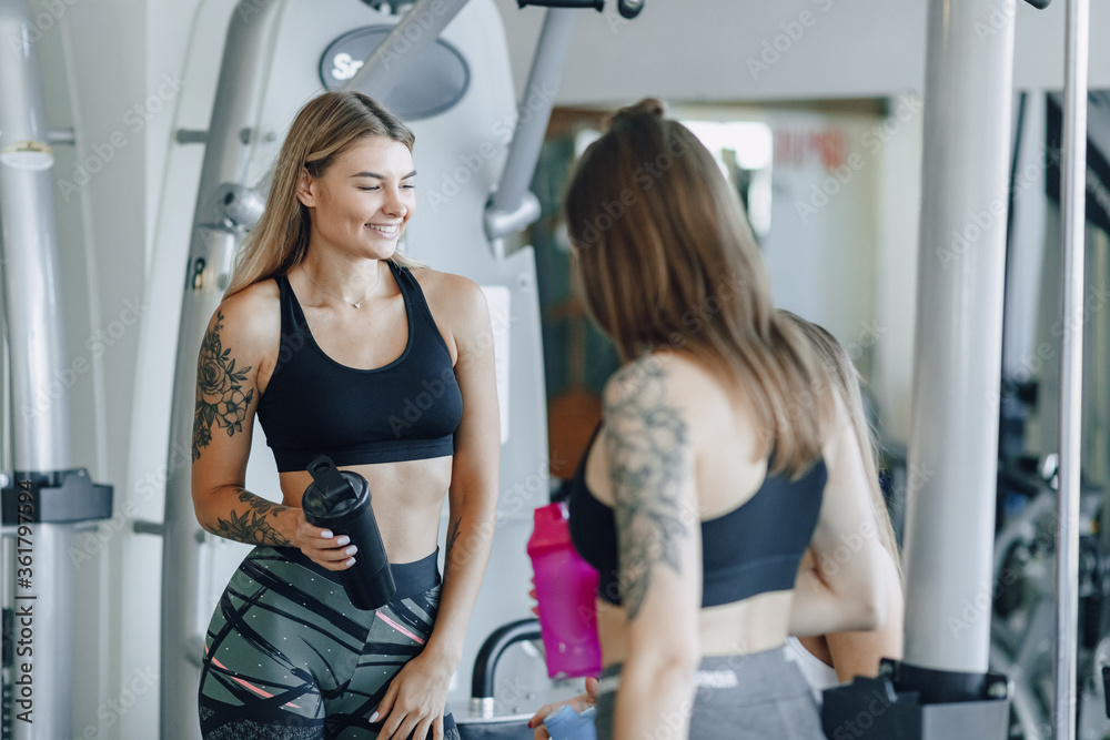 Fototapeta premium attractive girls in sportswear at the gym communicate. sports life and fitness atmosphere.