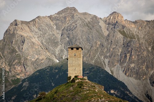 Ancient Medieval Castle Steinsberg in the small village of Ardez with the Swiss Alps. Engadin valley, Graubunden canton, Switzerland, Europe