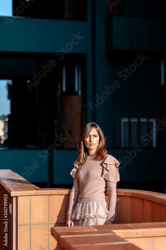 Mid adult beautiful woman leaning on balcony in a modern building