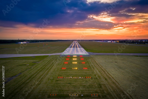 Aerial view on empty airport runaway with markings for landings and all navigation lights (ILS Cat II) on at the colorful sunset, clear for airplane landing or taking off in Wroclaw airport photo