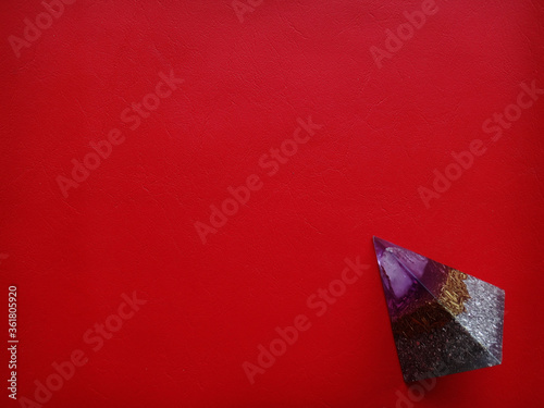 piramide de colores en fondo rojo texturado