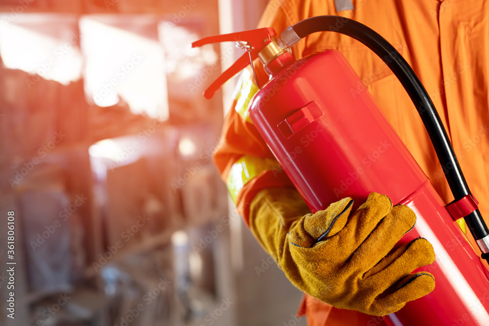 Fotografija Fireman hand holding fire extinguisher