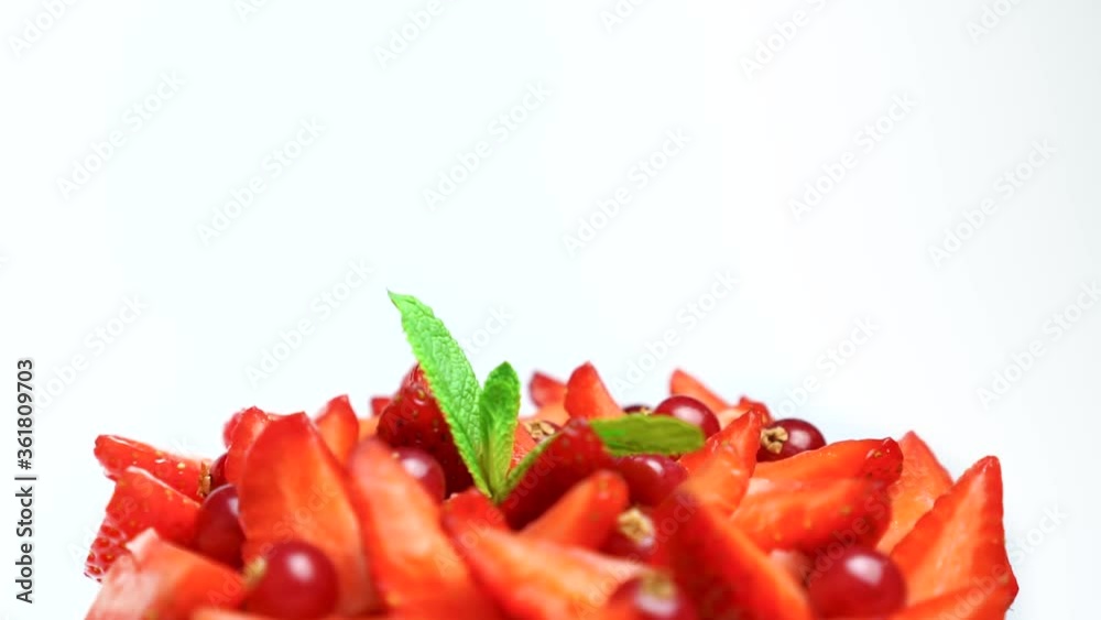 Delicious fruit salad dessert strawberries and mint with cranberries rotates high speed isolated on white background. Proper diet good nutrition food Delicious fruit salad dessert strawberries and mint with cranberries rotates high speed isolated on white background. Proper diet good nutrition food