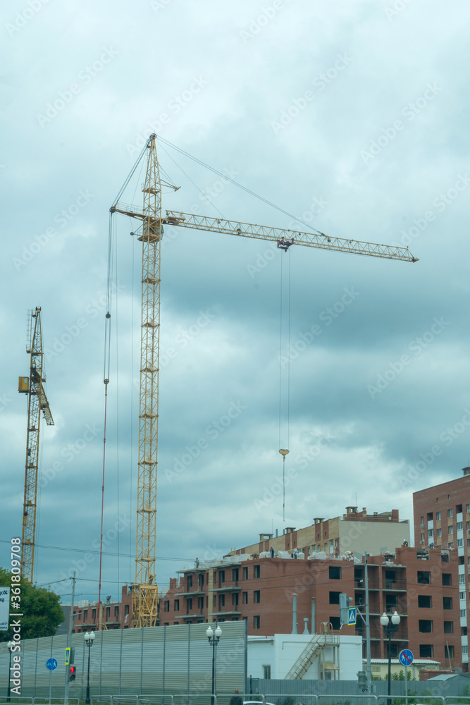A crane on a construction site against a cloudy sky