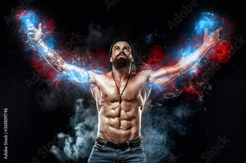 Athlete bodybuilder in blue energy lights. Bodybuilder posing. Beautiful sporty guy male power. Fitness muscled man. Spot concept