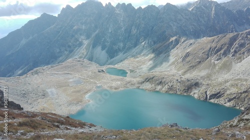 Fototapeta Naklejka Na Ścianę i Meble -  Crystal clear lake between mountains, with mountain chain in the background