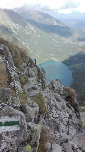 Mountainside with a clear lake in background and glen between mountains.