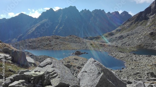 Crystal clear lake with a mountains landscape background. Syn rays shining.