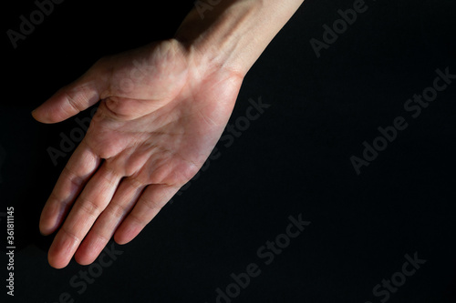Opening hand on black background, Right hand of Asian woman, Dark tone