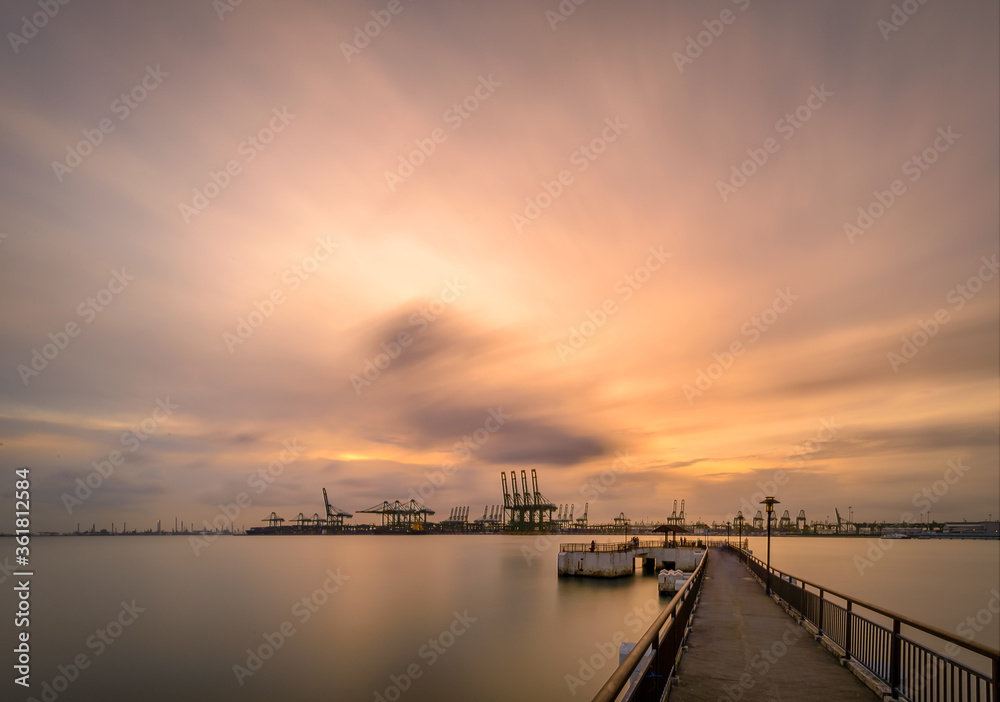 Long cranes and view over the Singapore port, habour front during sunrise 
