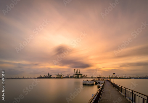 Long cranes and view over the Singapore port, habour front during sunrise 