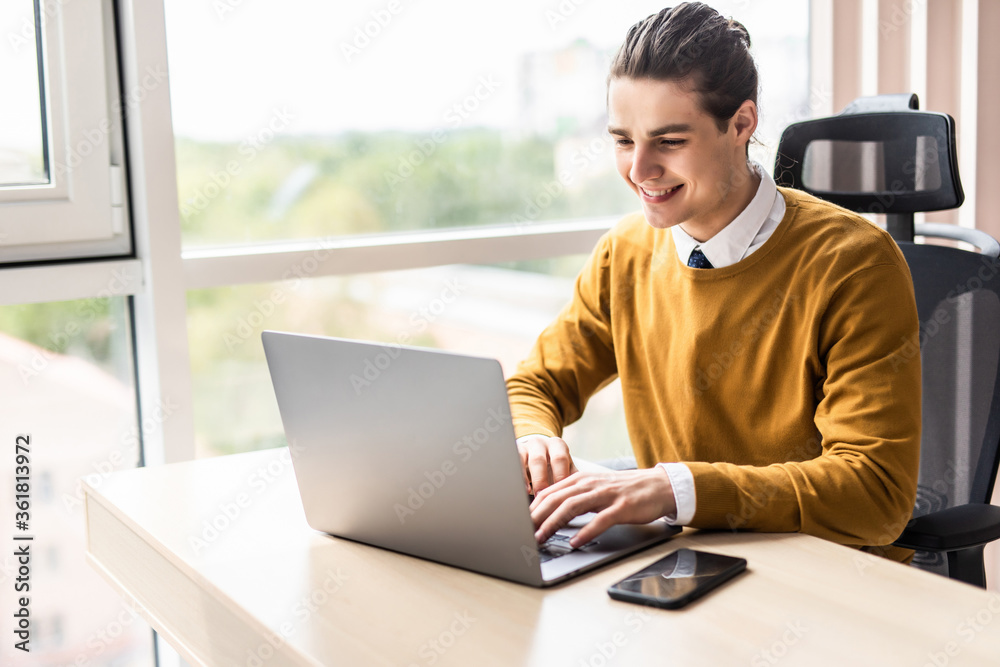 Handsome businessman working at modern office on laptop Handsome businessman working at modern office on laptop